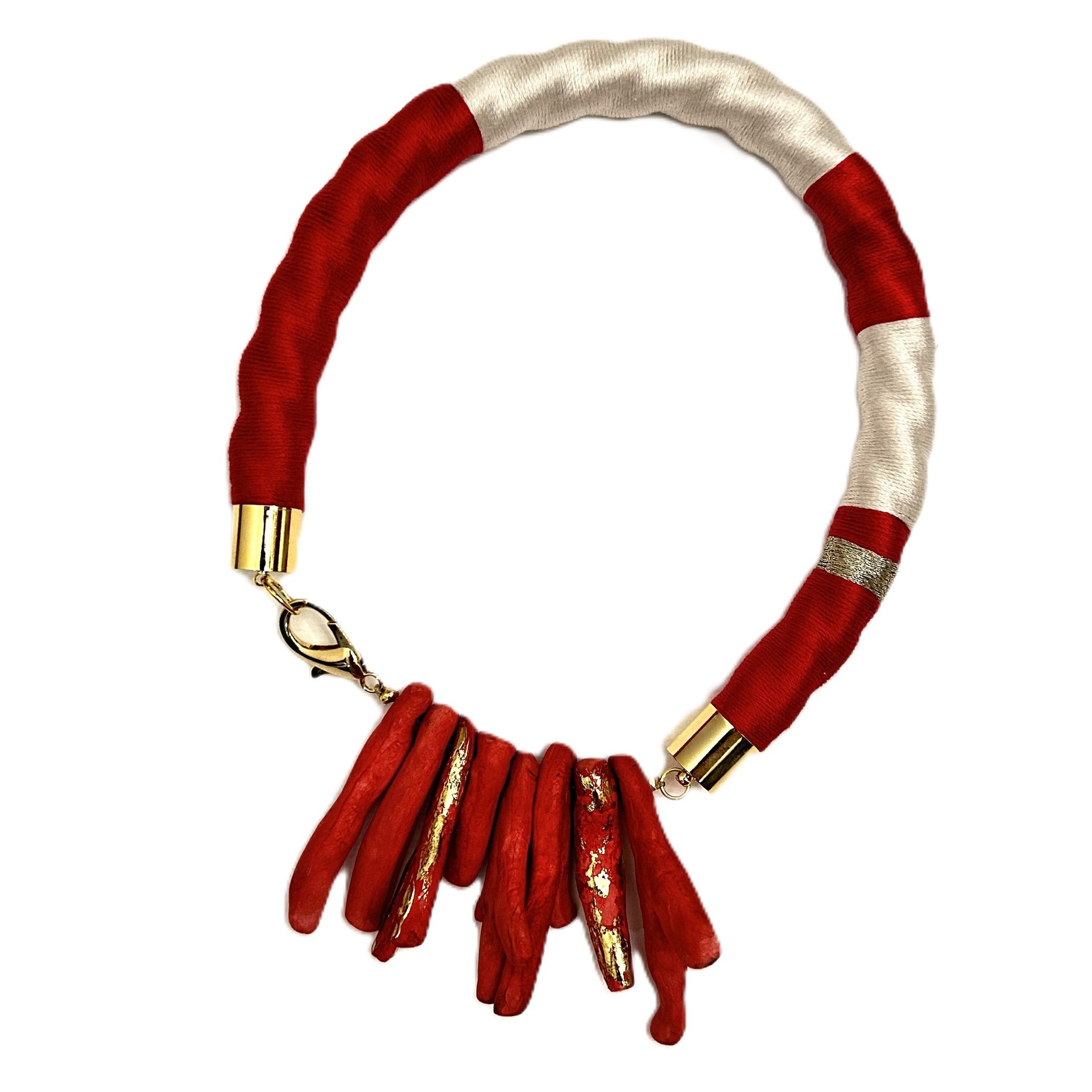 Un collar rojo y blanco con un cierre dorado.