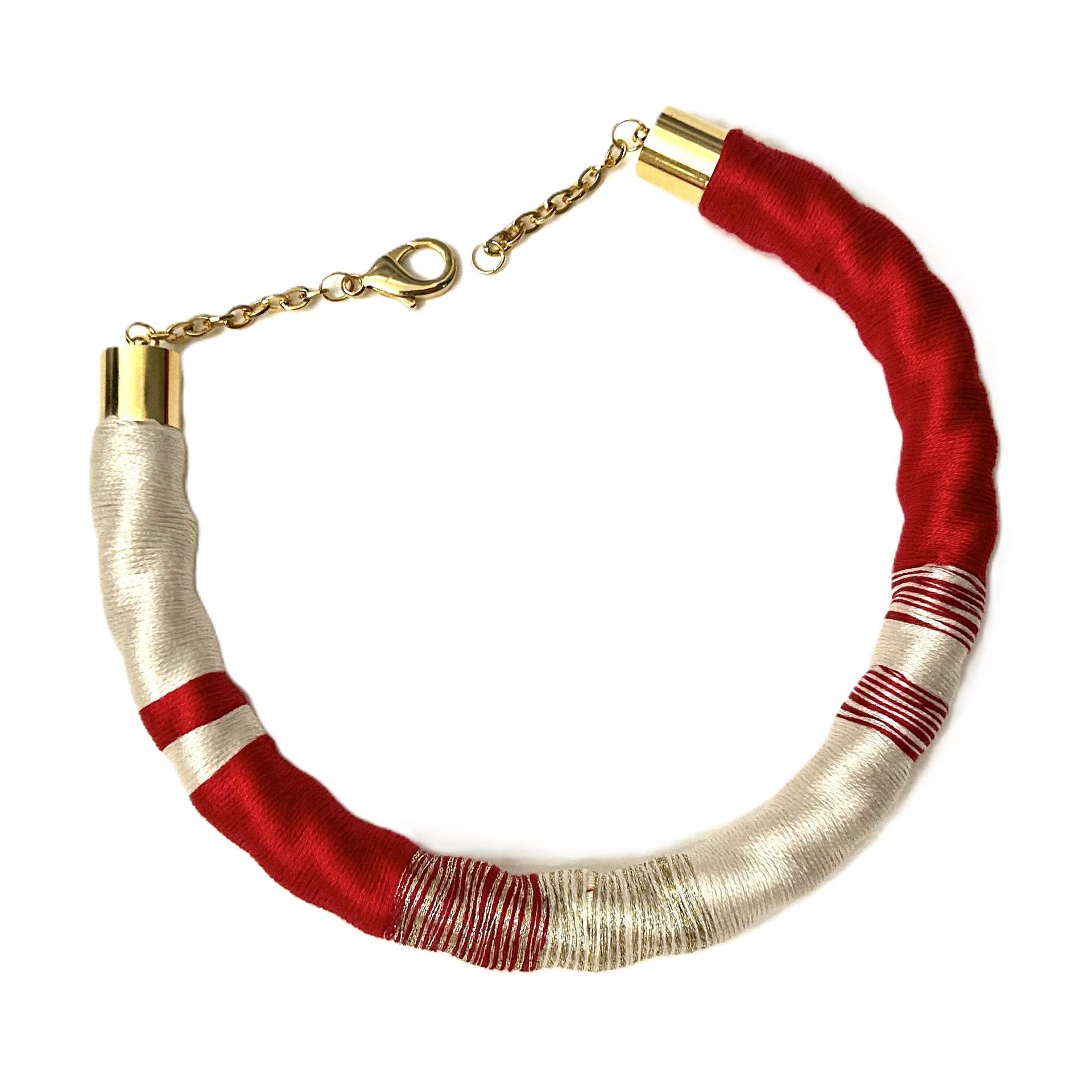 Un collar rojo y blanco con una cadena de oro