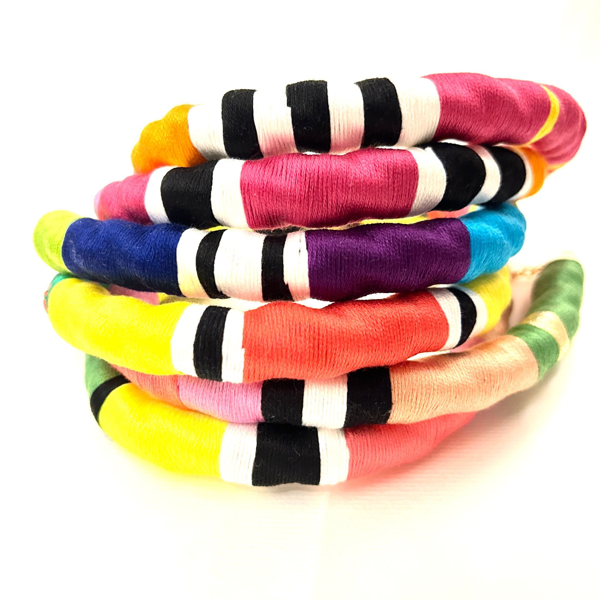 Un montón de pulseras de colores se apilan una encima de otra.