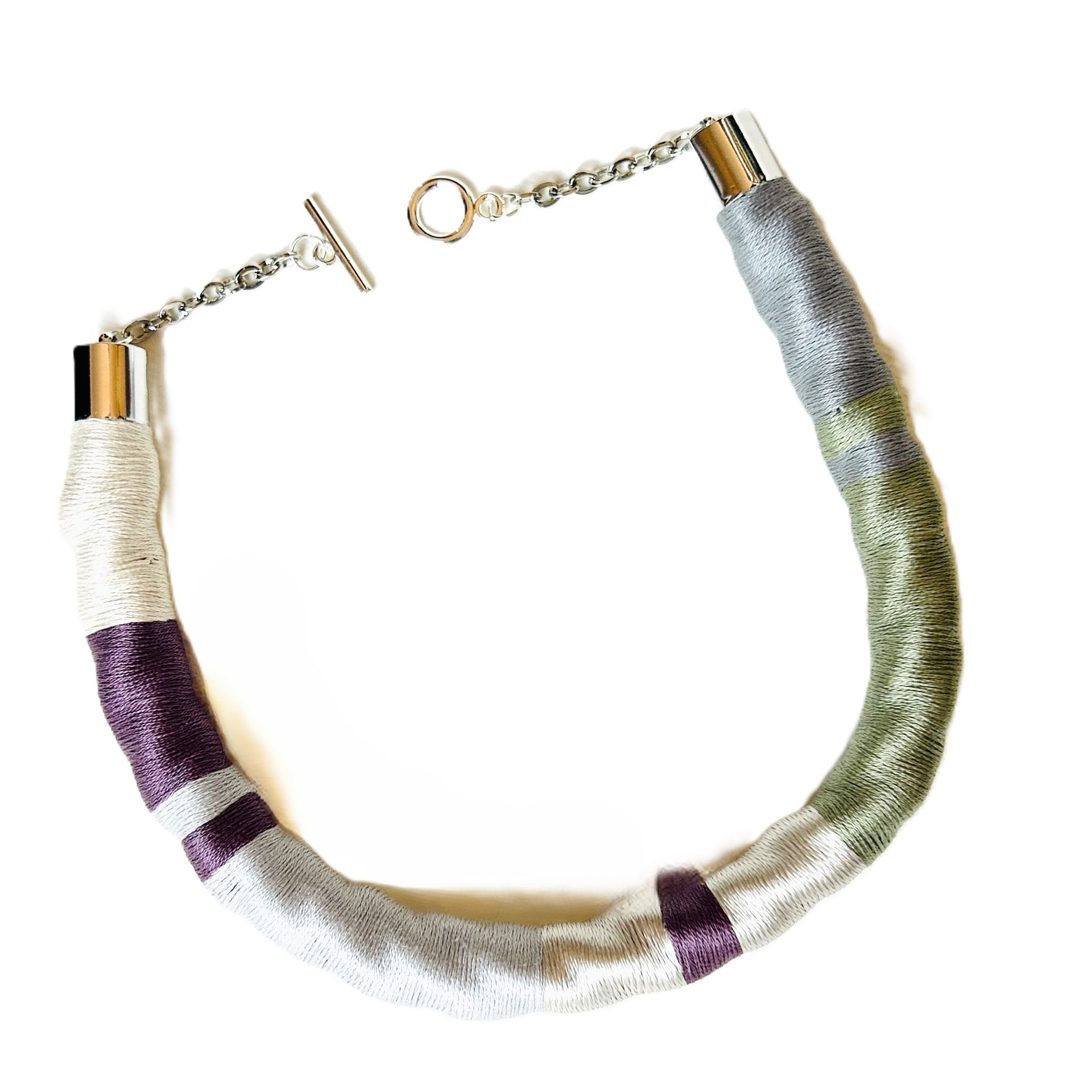 Un collar morado y blanco con un cierre de plata.