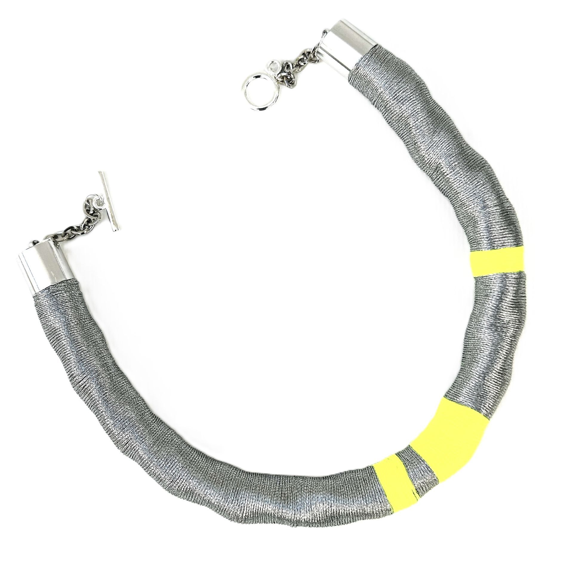 Un collar gris y amarillo con un cierre de plata.