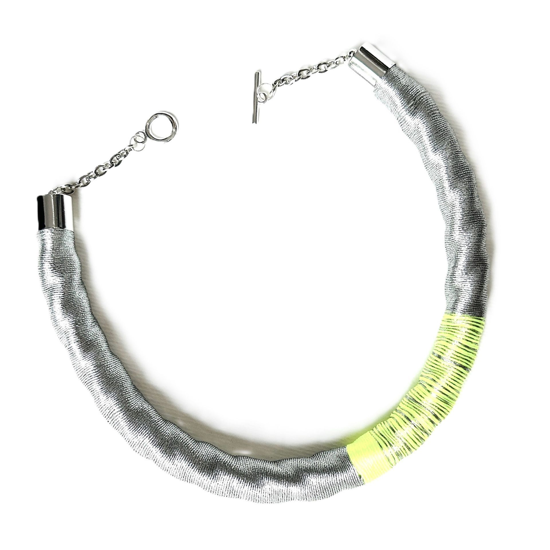 Un collar de plata con una raya amarilla en el extremo.