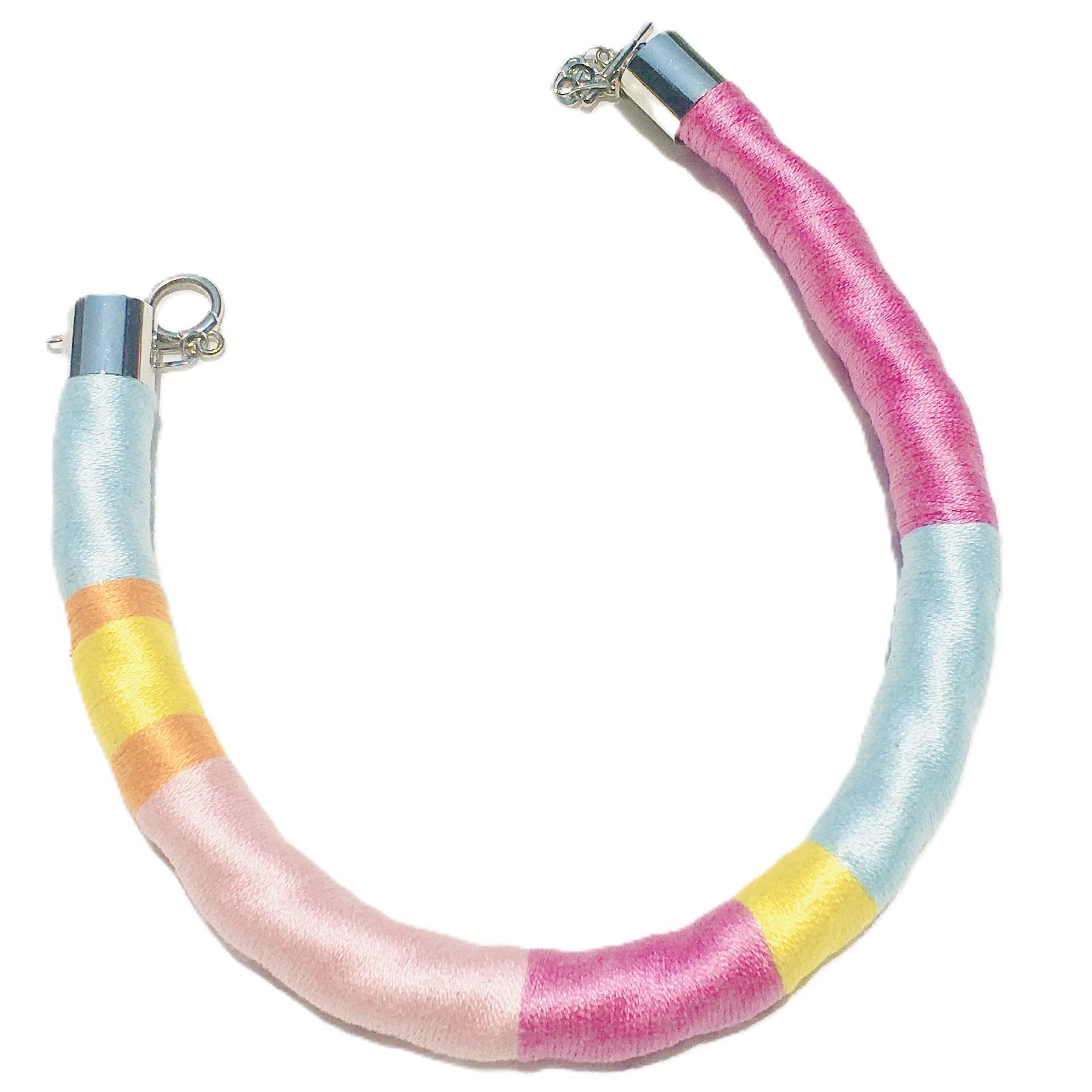 Una pulsera rosa, azul y amarilla con un cierre de plata.