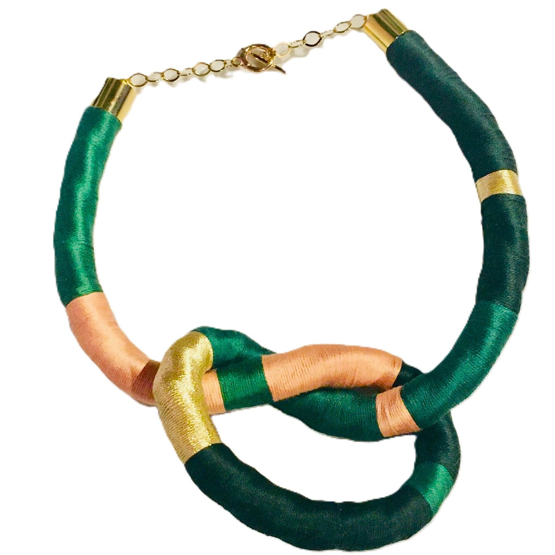 Un collar verde y dorado con un cierre dorado.