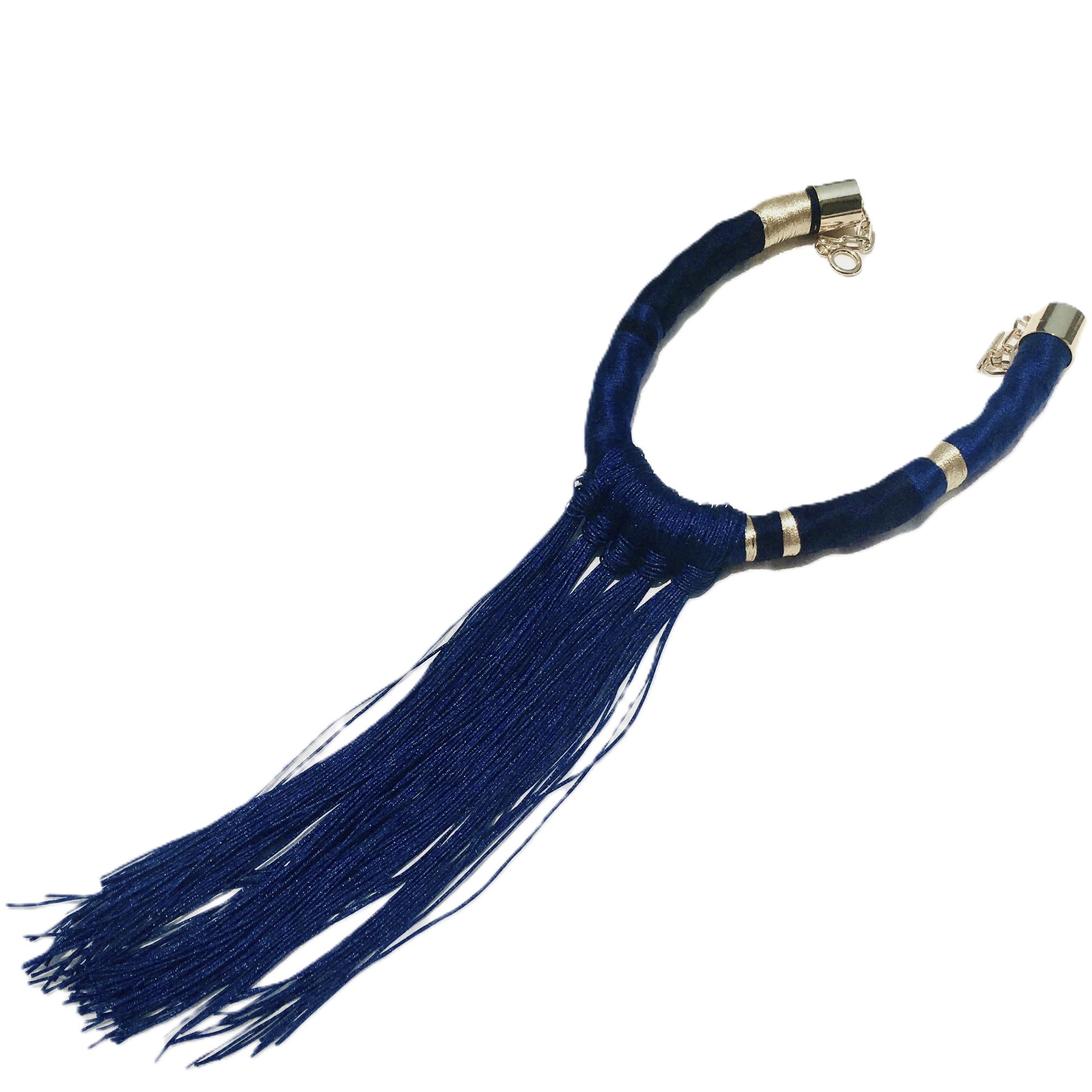 Un collar azul con cierre dorado y flecos.