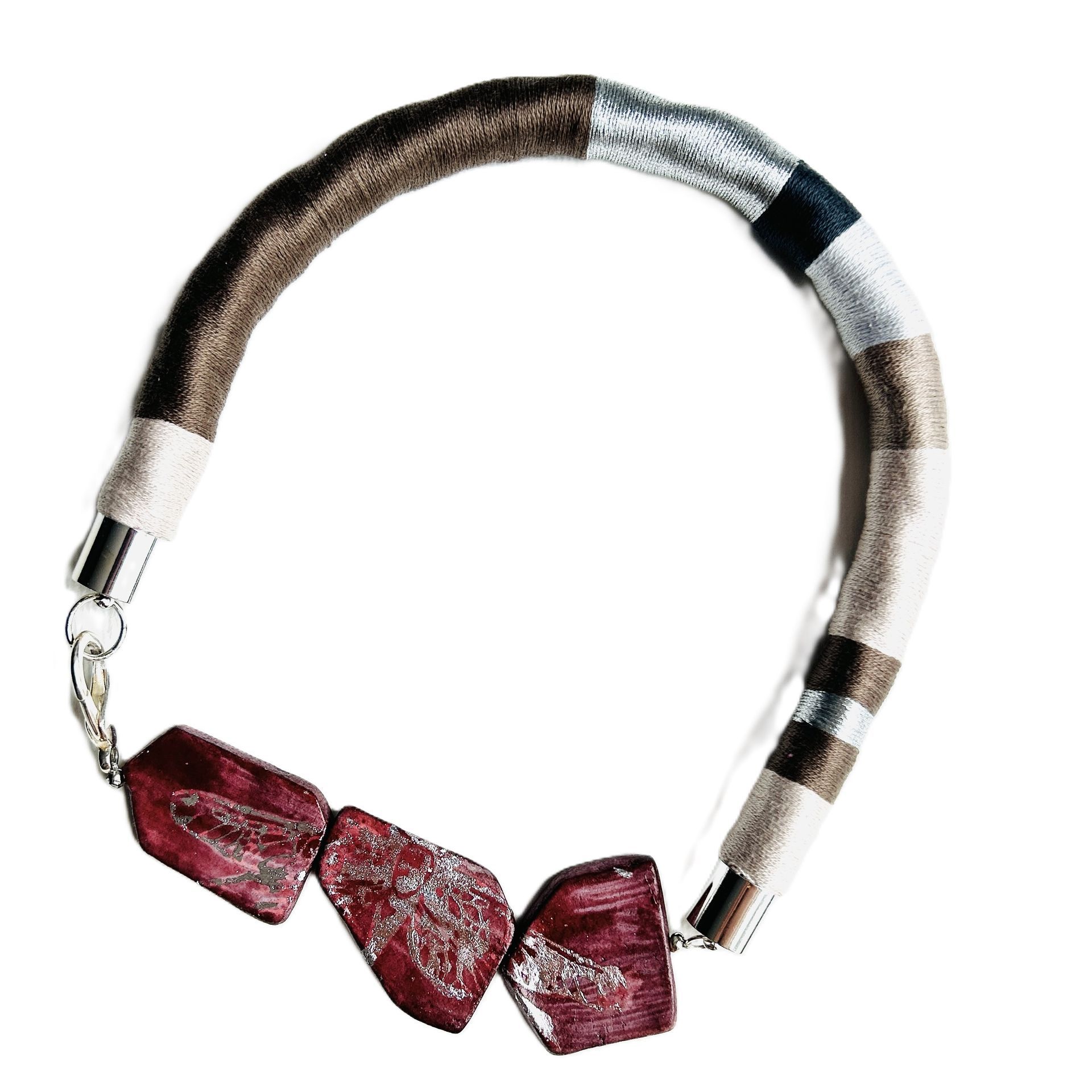 Un primer plano de un collar con cuentas rojas sobre un fondo blanco.