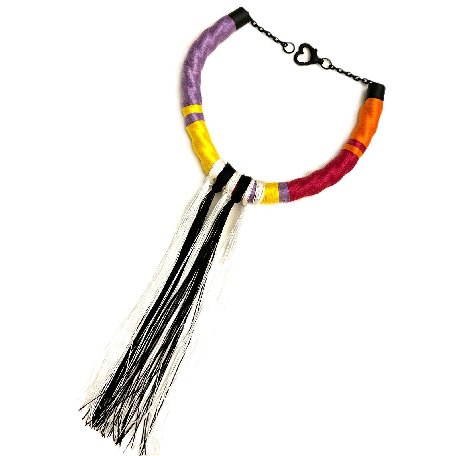 Un collar colorido con una borla blanca y negra.