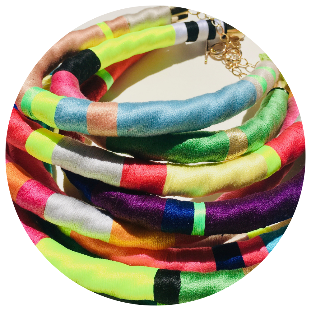 Un montón de collares de colores están apilados uno encima del otro.
