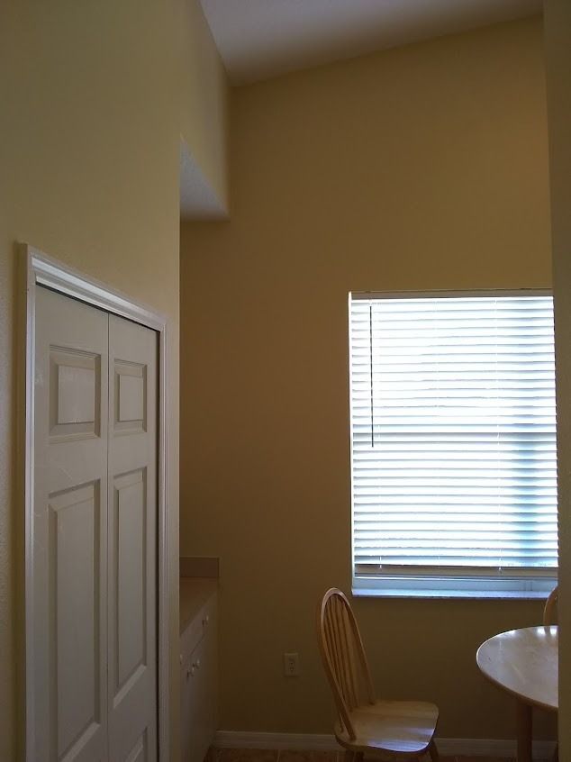 Closet door next to a narrow dining area with a window and chair