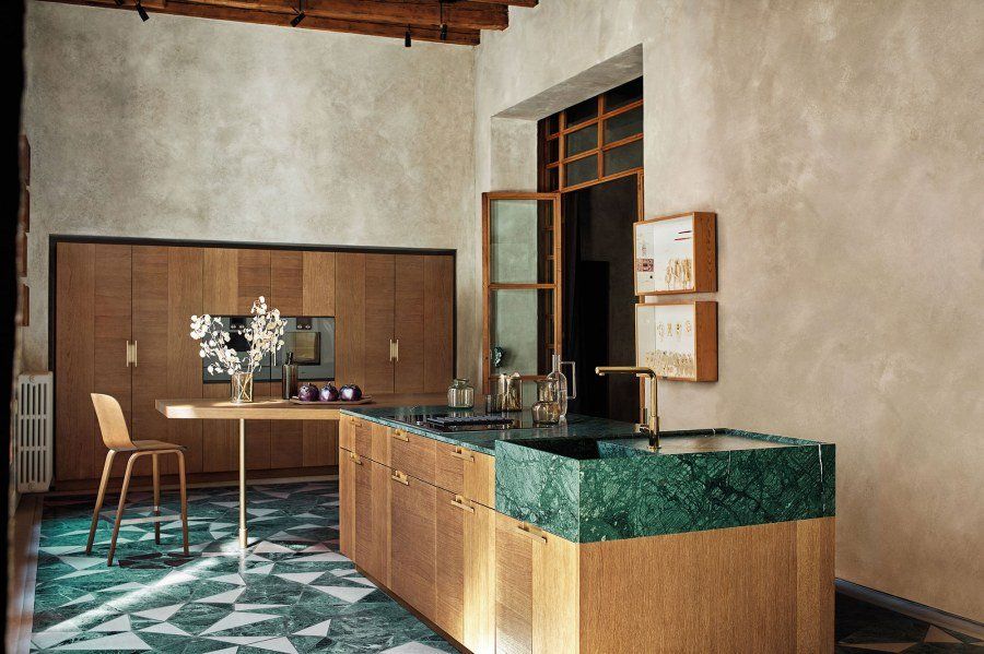 cucina open space con mobili in legno chiaro e bianchi