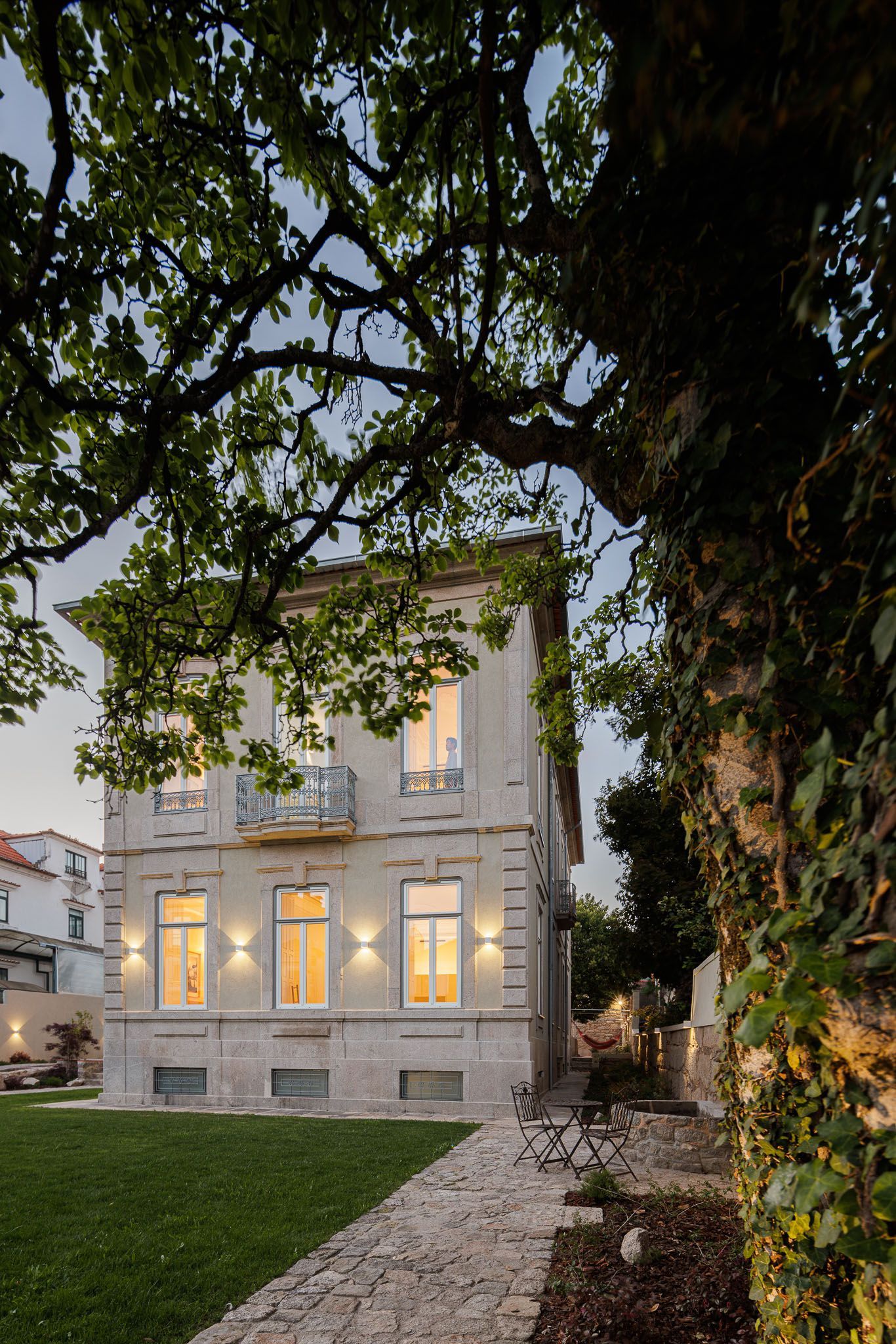 Casa Kala façade at dusk, framed by magnolia tree
