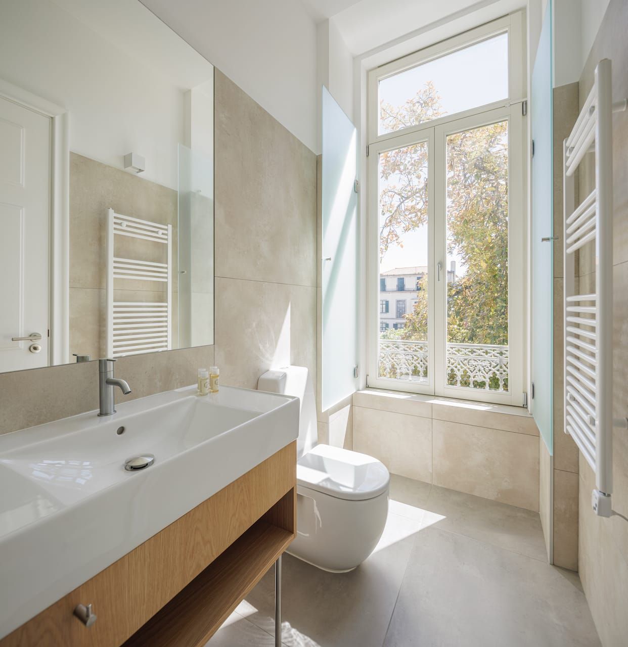 Private modern bathroom with large mirror and walk-in shower