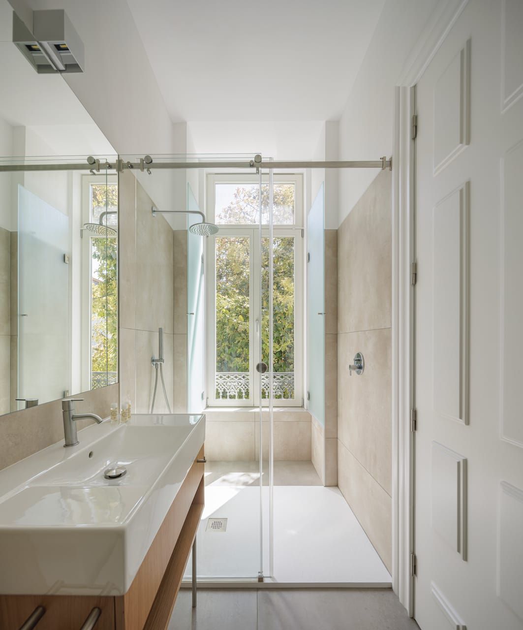 Interior of Casa Kala. Private modern bathroom with large mirror and walk-in shower, large windows