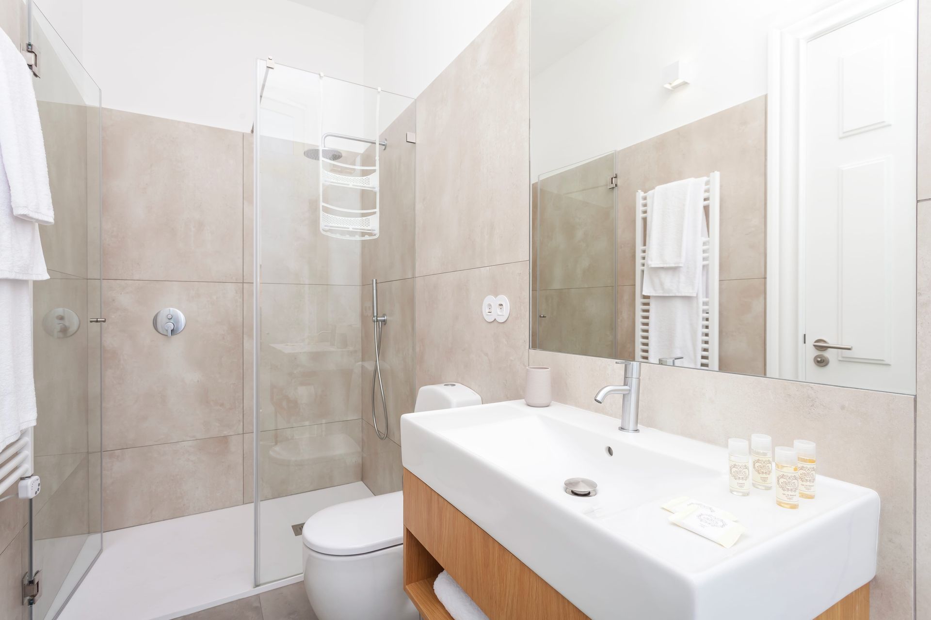 Private modern bathroom with large mirror and walk-in shower