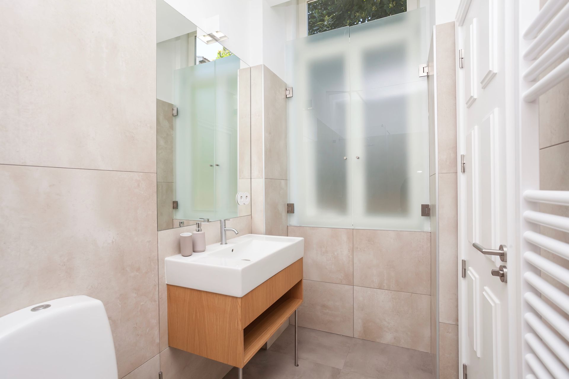 Private modern bathroom with large mirror and walk-in shower
