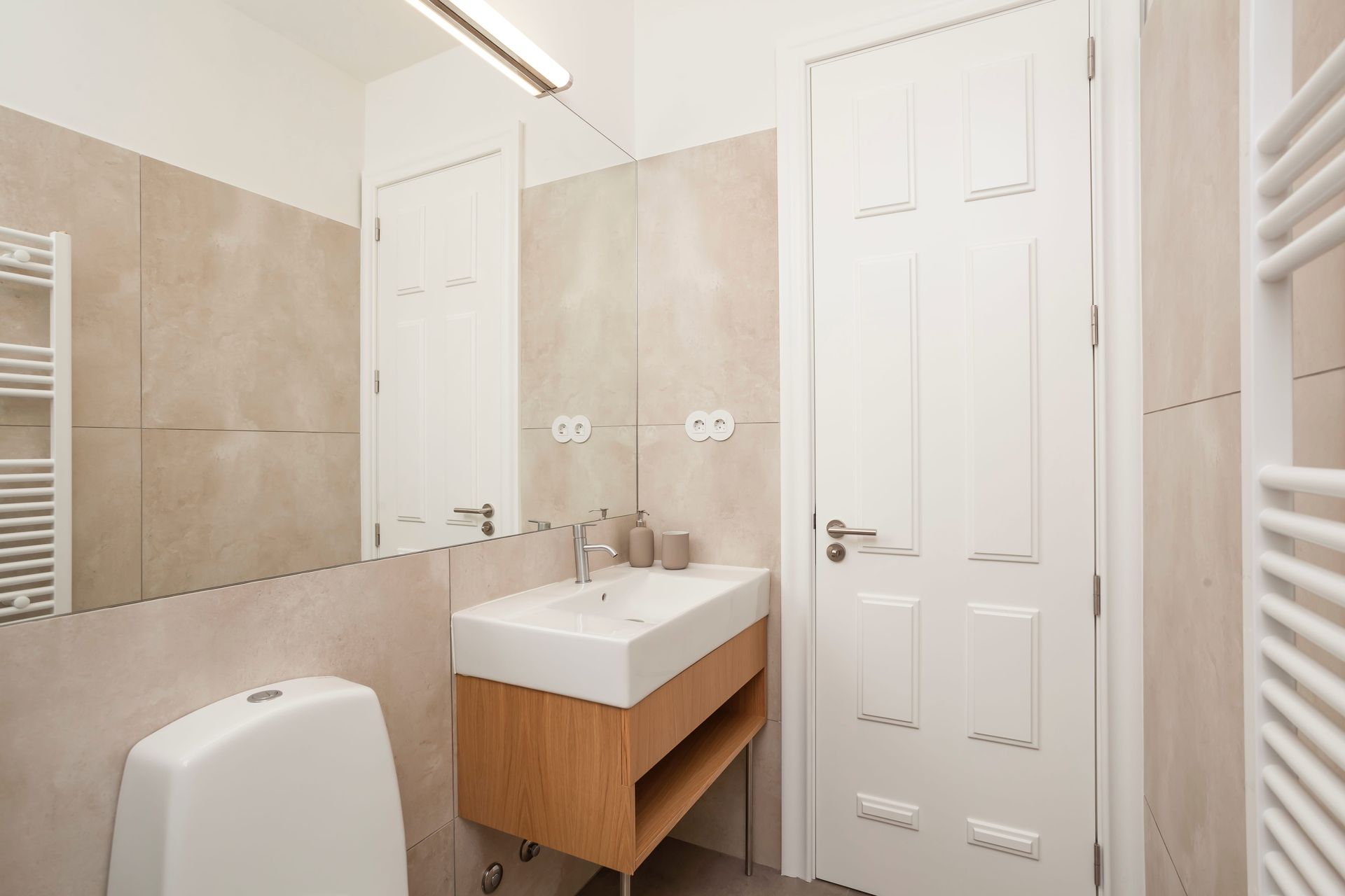 Private modern bathroom with large mirror and walk-in shower