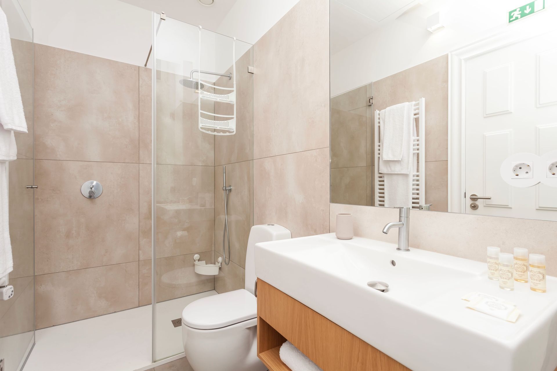 Private modern bathroom with large mirror and walk-in shower