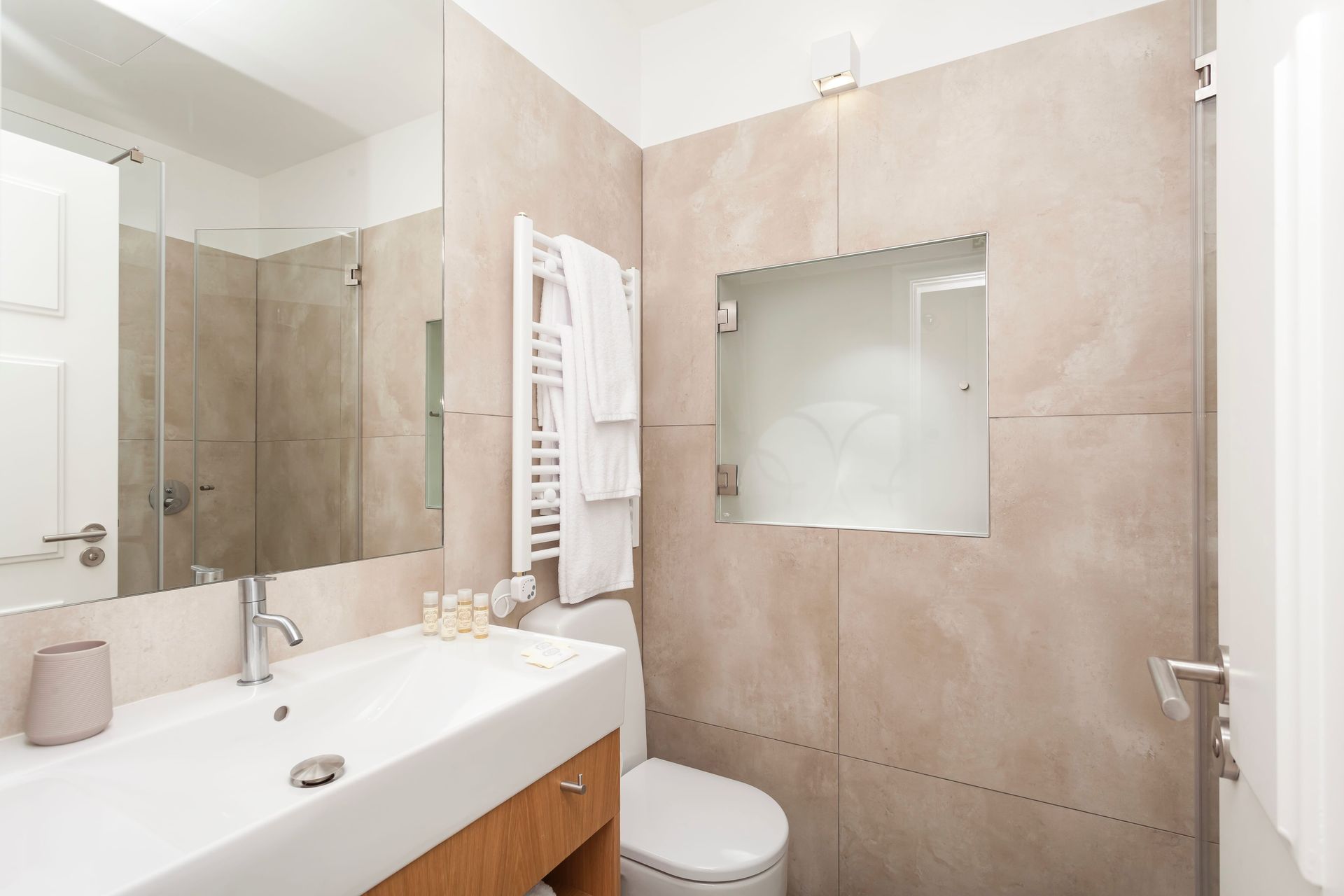 Private modern bathroom with large mirror and walk-in shower