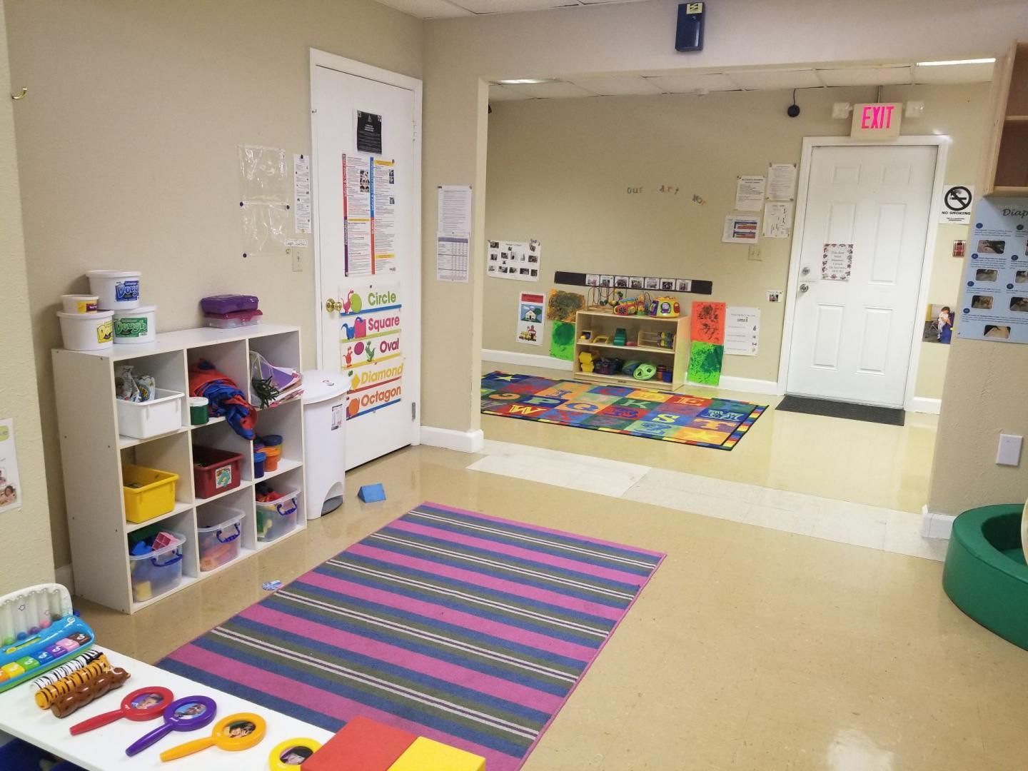 A room with a purple rug and a table with toys on it.