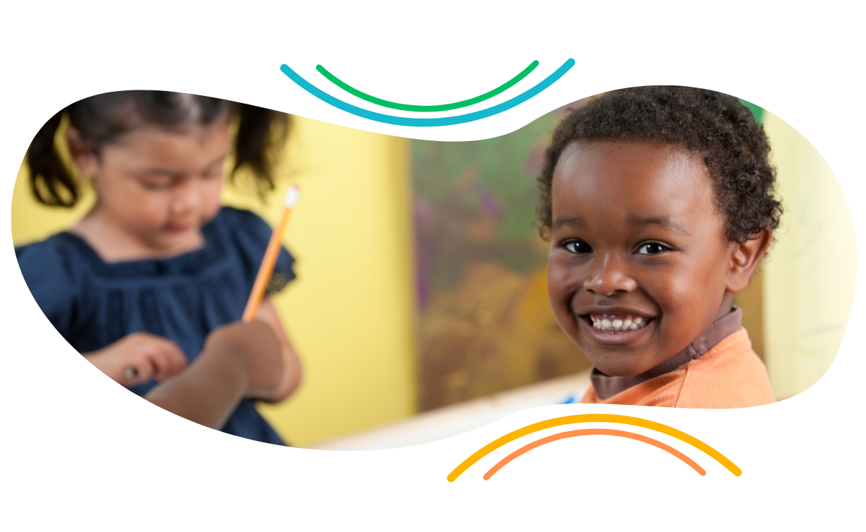 A boy and a girl are smiling and holding pencils.