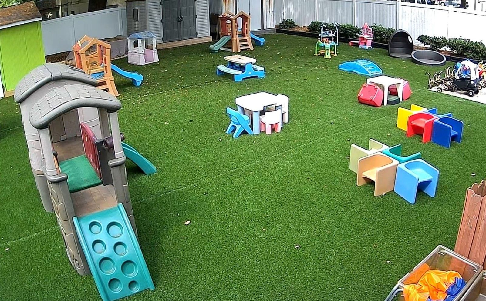 A playground with tables , chairs , and a slide.
