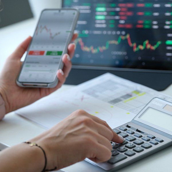 Woman looking at financial records on a computer and calculator