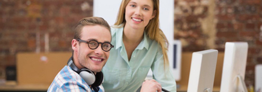 Two colleagues in an office looking at the camera