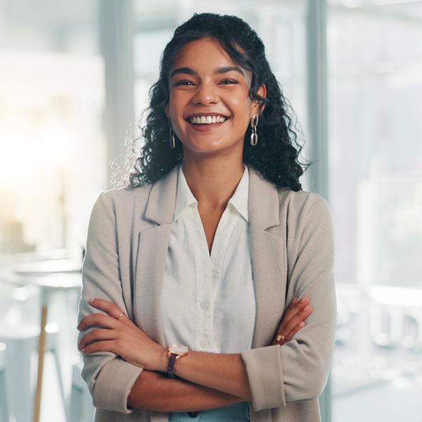 Young woman with long dark curly hair looking at the camera and smiling