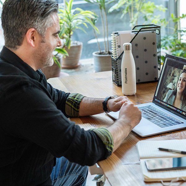 Man sitting at a desk chatting to a colleague via video conference