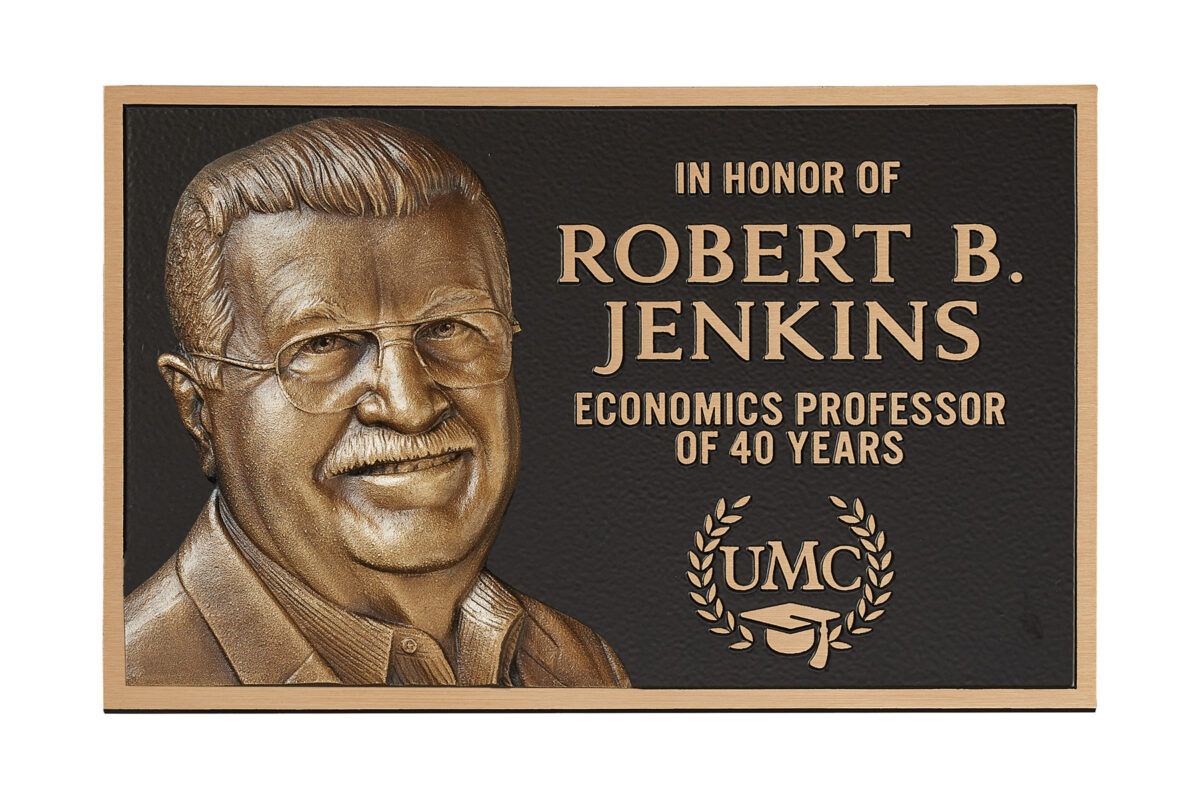 Bronze plaque on a dark stone, reading