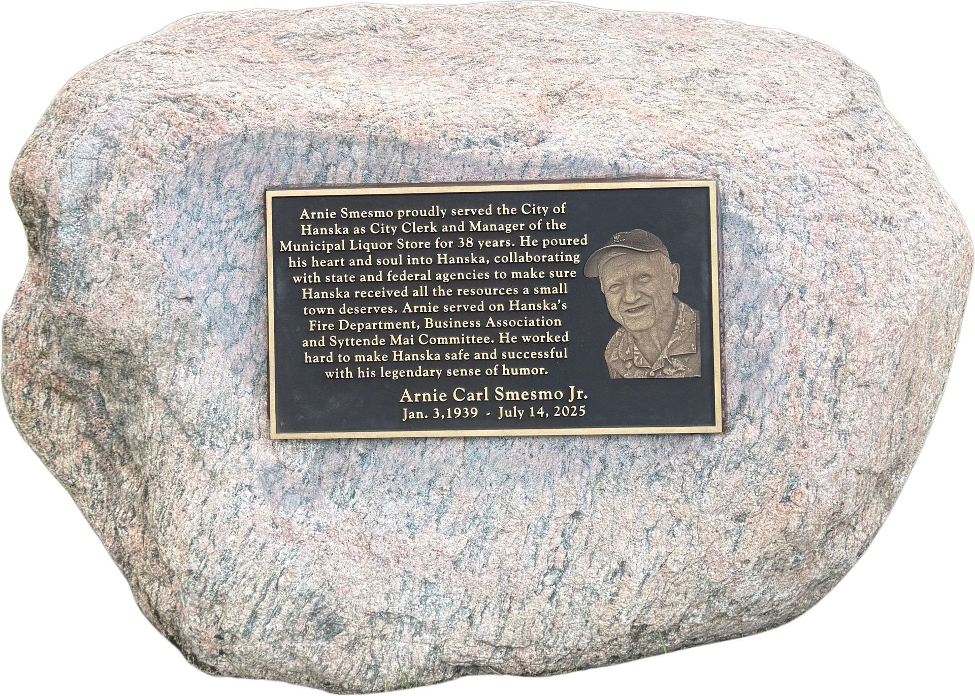 Black granite memorial with golden cross and inscription: 