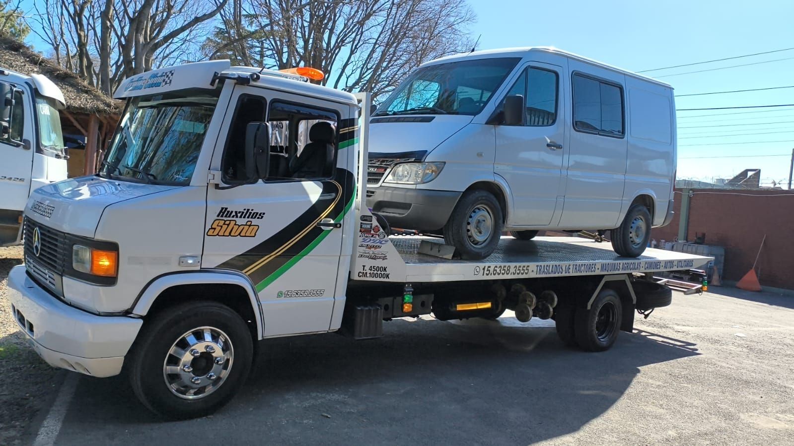 Una grúa transporta un SUV gris en una calle de la ciudad, con la palabra