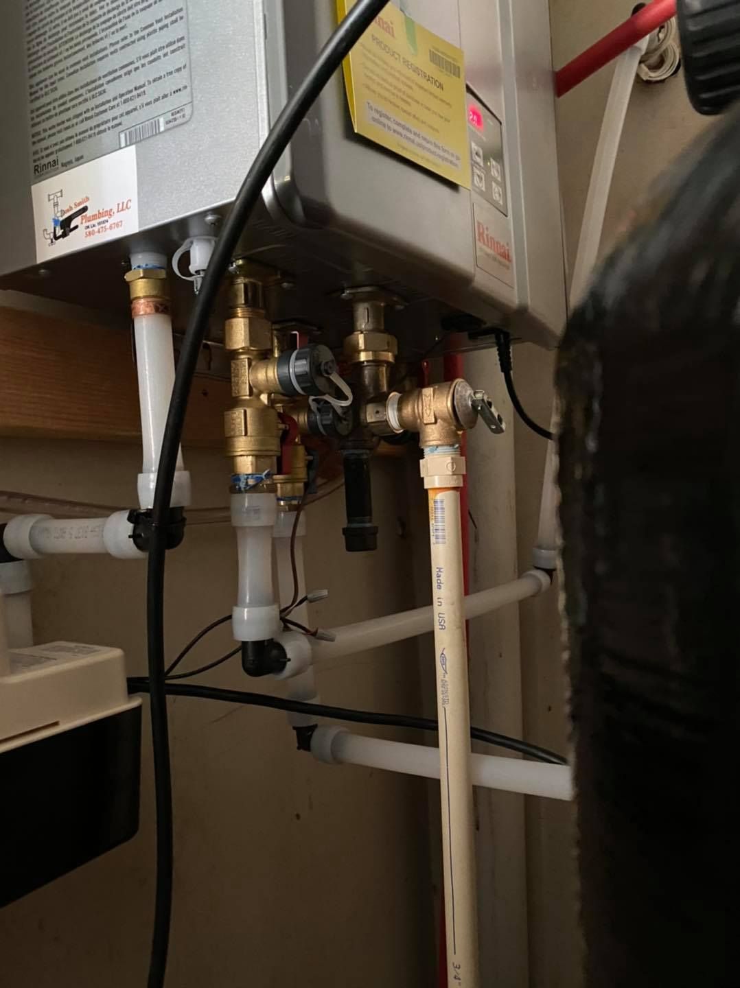 A water heater is connected to a water tank in a bathroom.