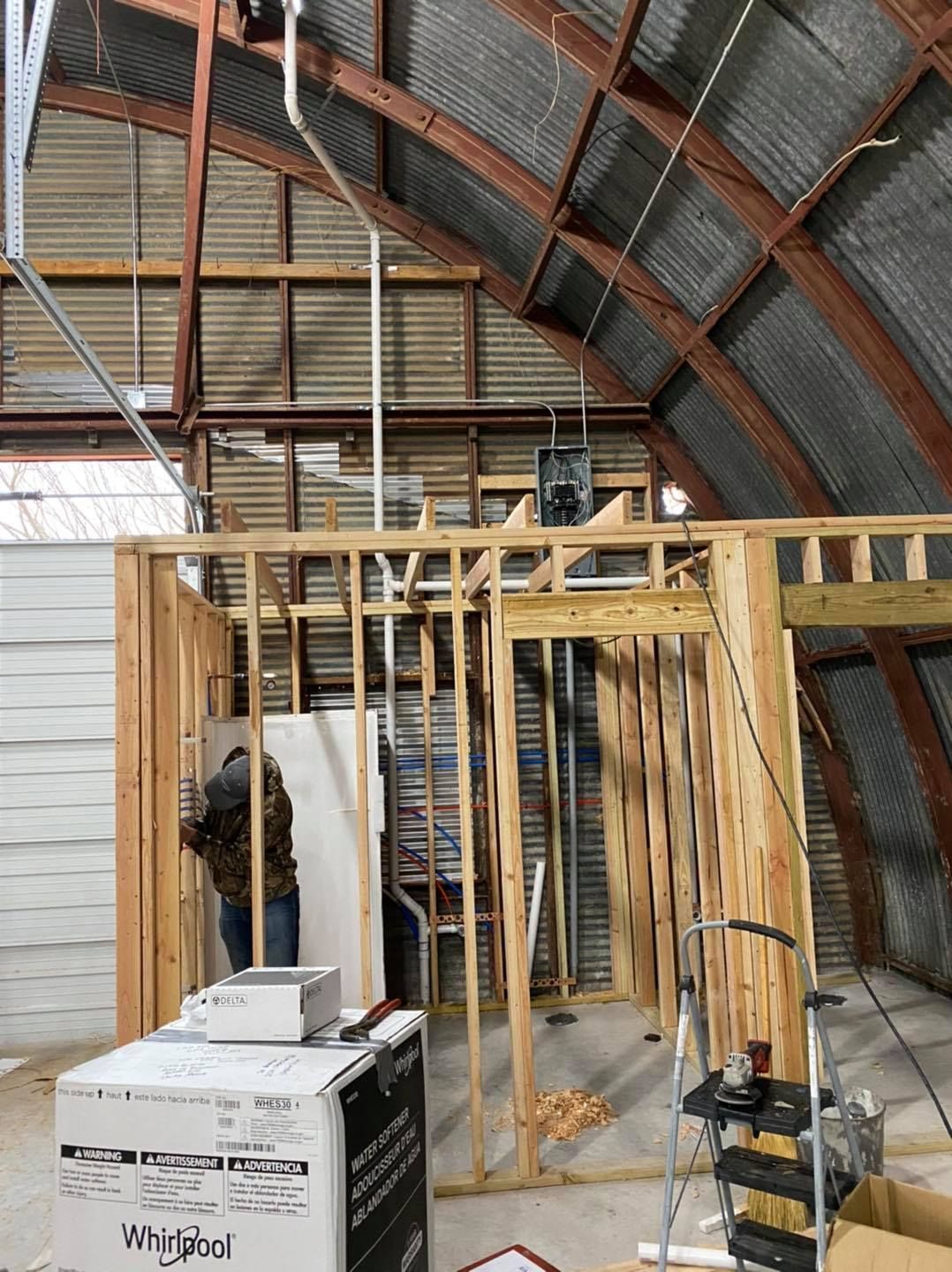 A man is standing in a room that is being built.
