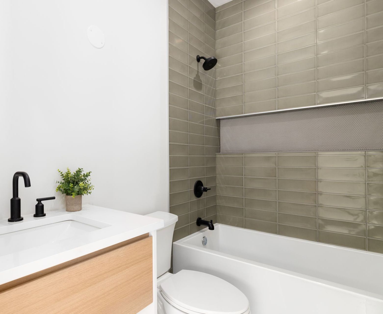A bathroom with a toilet , sink and bathtub.
