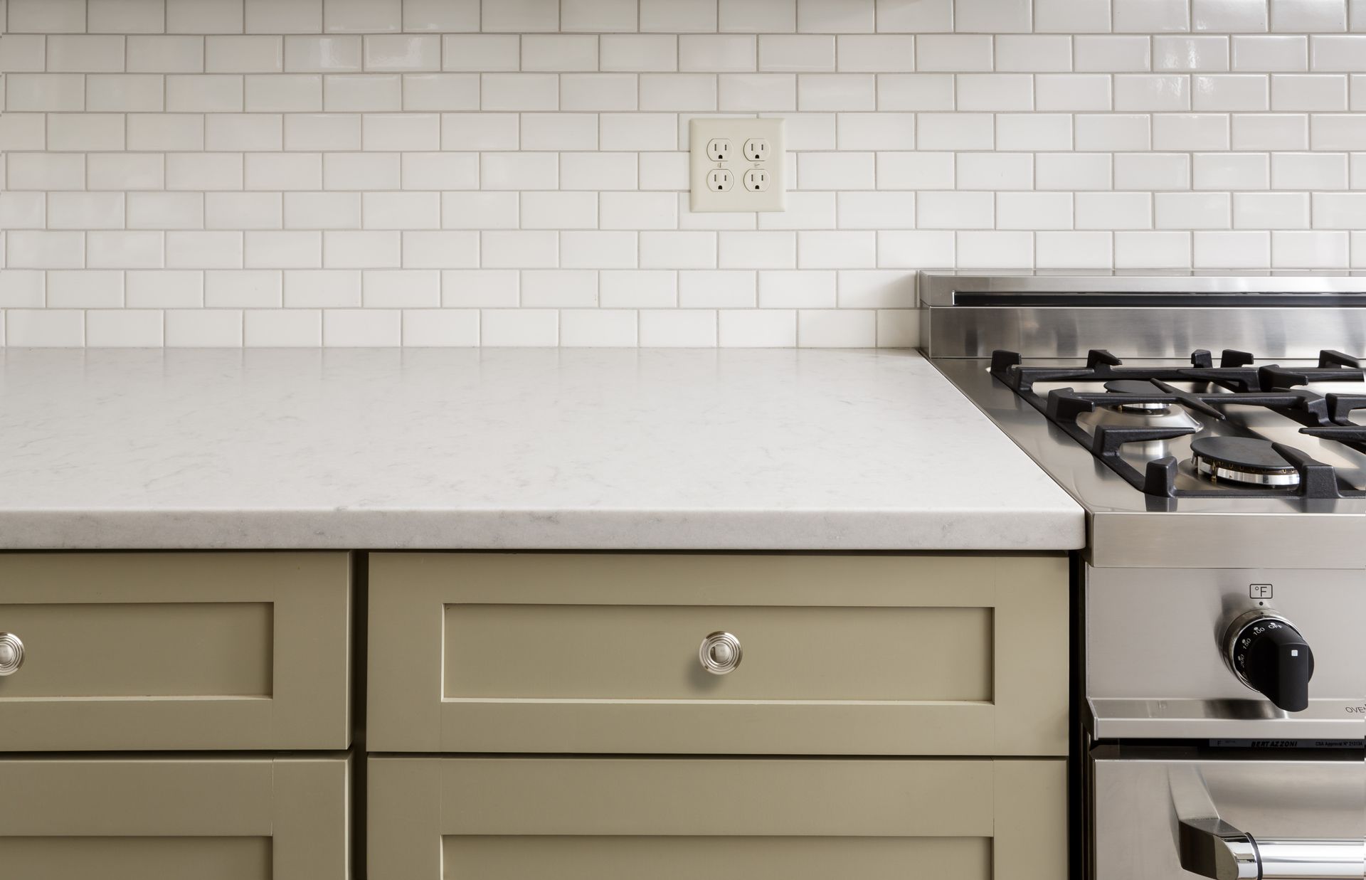 A kitchen with a stove top oven and drawers