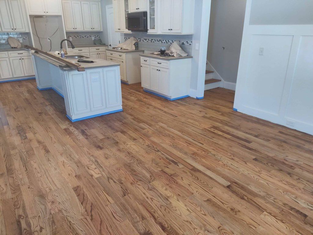 A kitchen with hardwood floors and white cabinets.