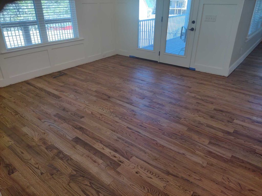A living room with hardwood floors and a sliding glass door.