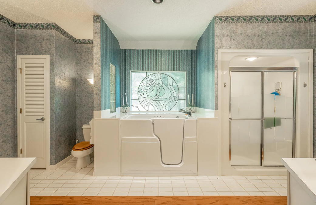 A bathroom with a walk in tub , toilet , and shower.