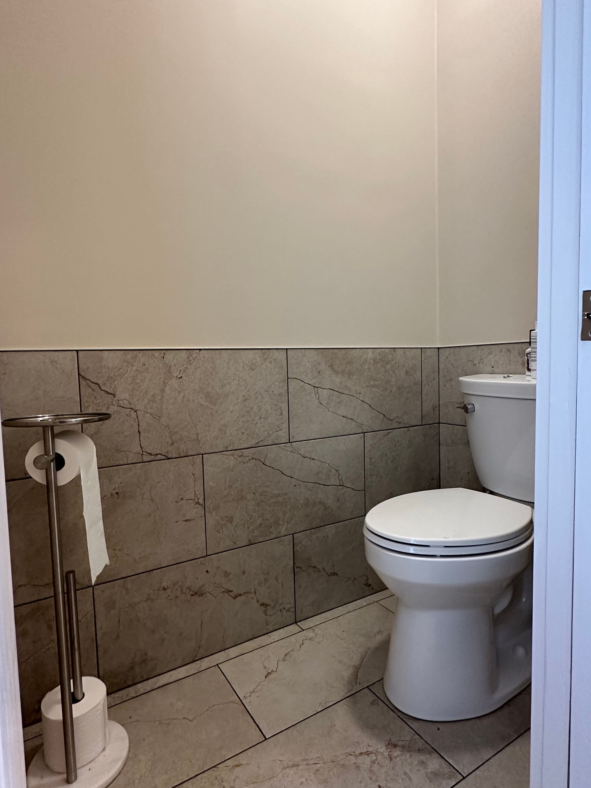 A bathroom with a toilet and a paper towel holder
