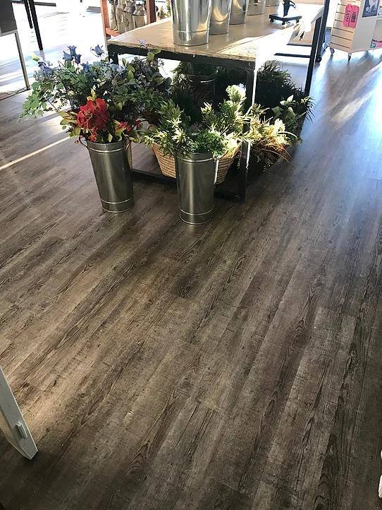 There are buckets of flowers on the floor in a room.