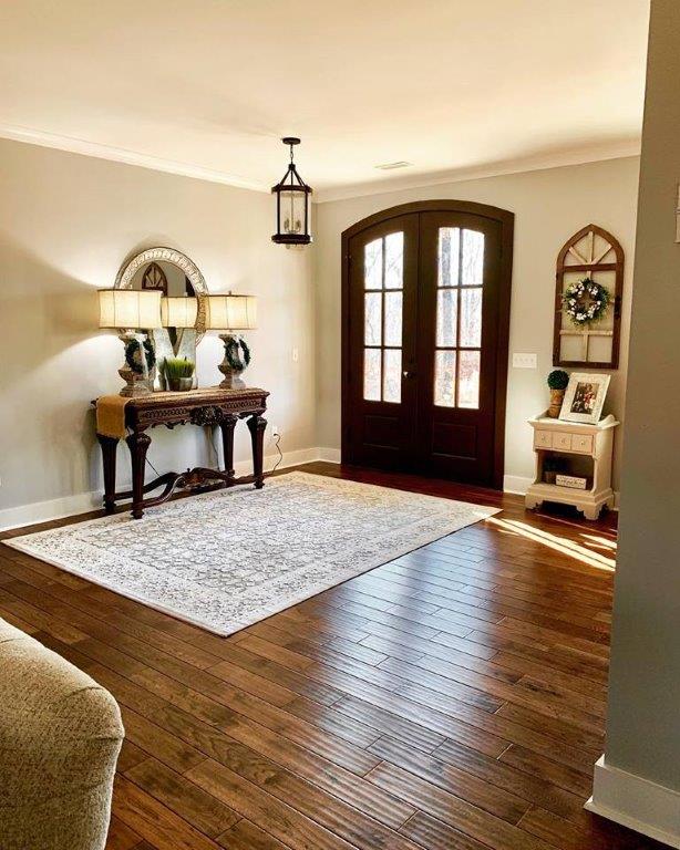 A living room with hardwood floors , a table and a rug.
