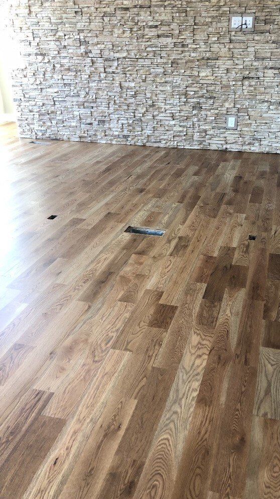 A room with a wooden floor and a stone wall.