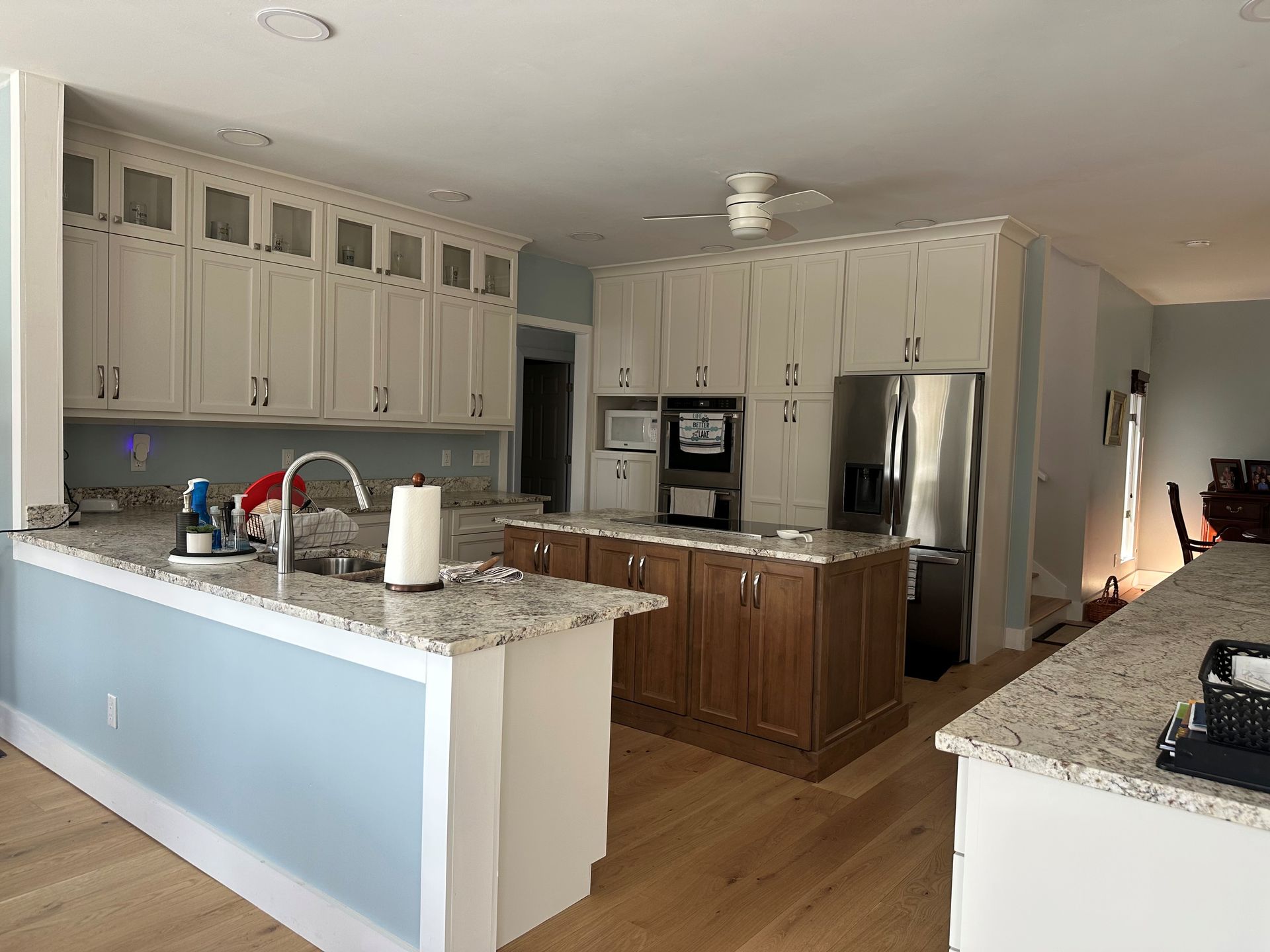 A kitchen with white cabinets and granite counter tops.