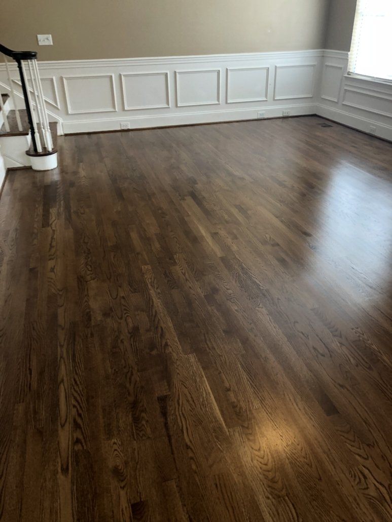 A living room with hardwood floors and white trim.