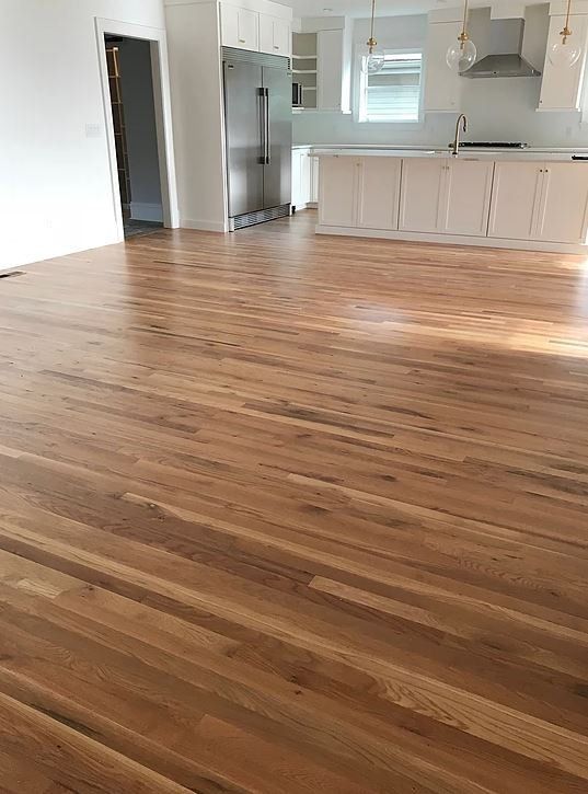 A kitchen with a wooden floor and white cabinets.