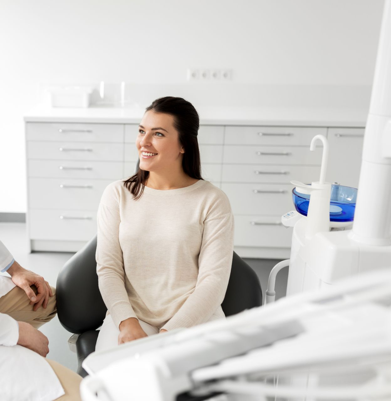 Doctor talking with a smiling patient in a bright medical exam room