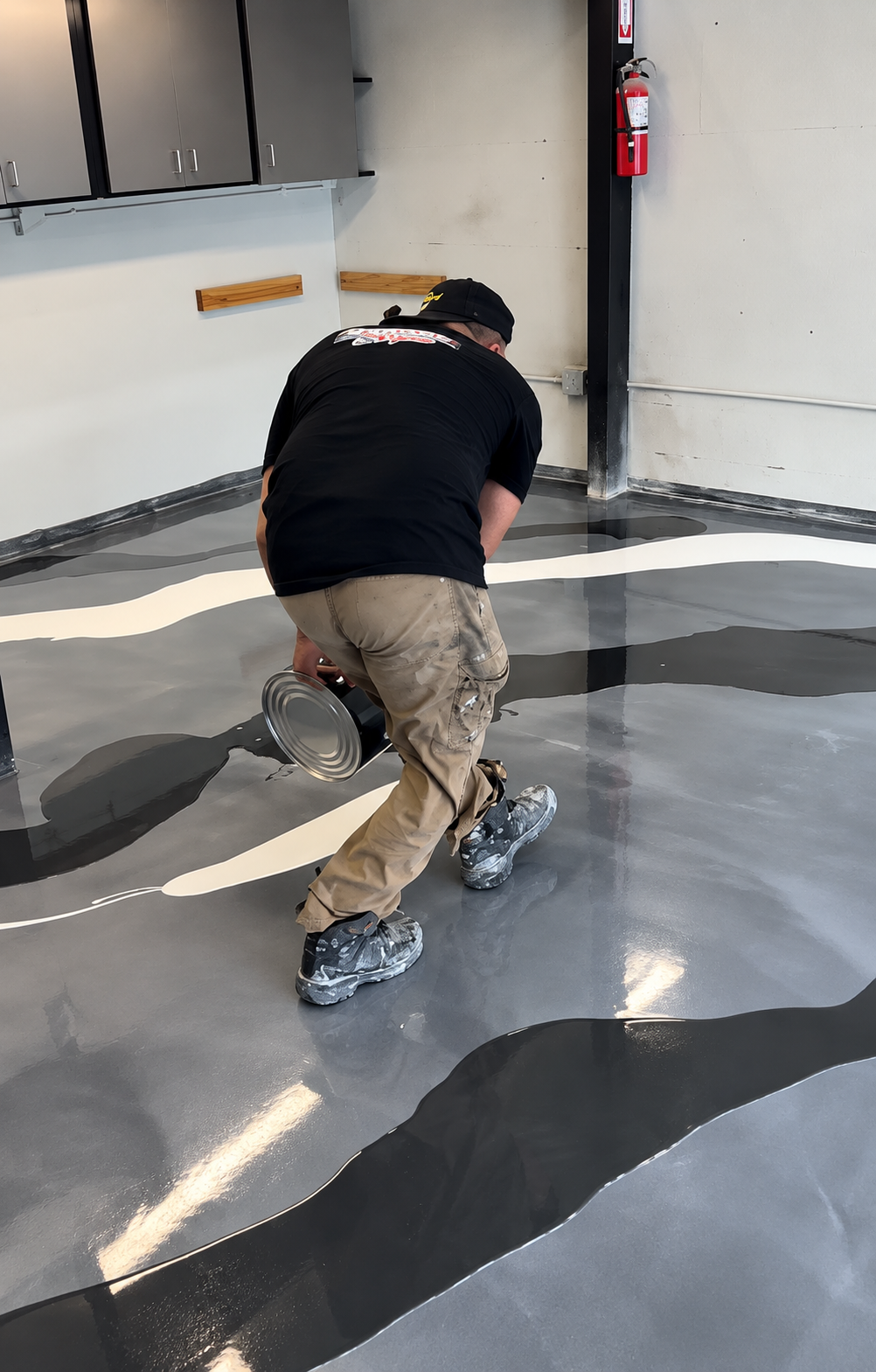 Person crouching on a glossy indoor floor with black and white abstract patterns.
