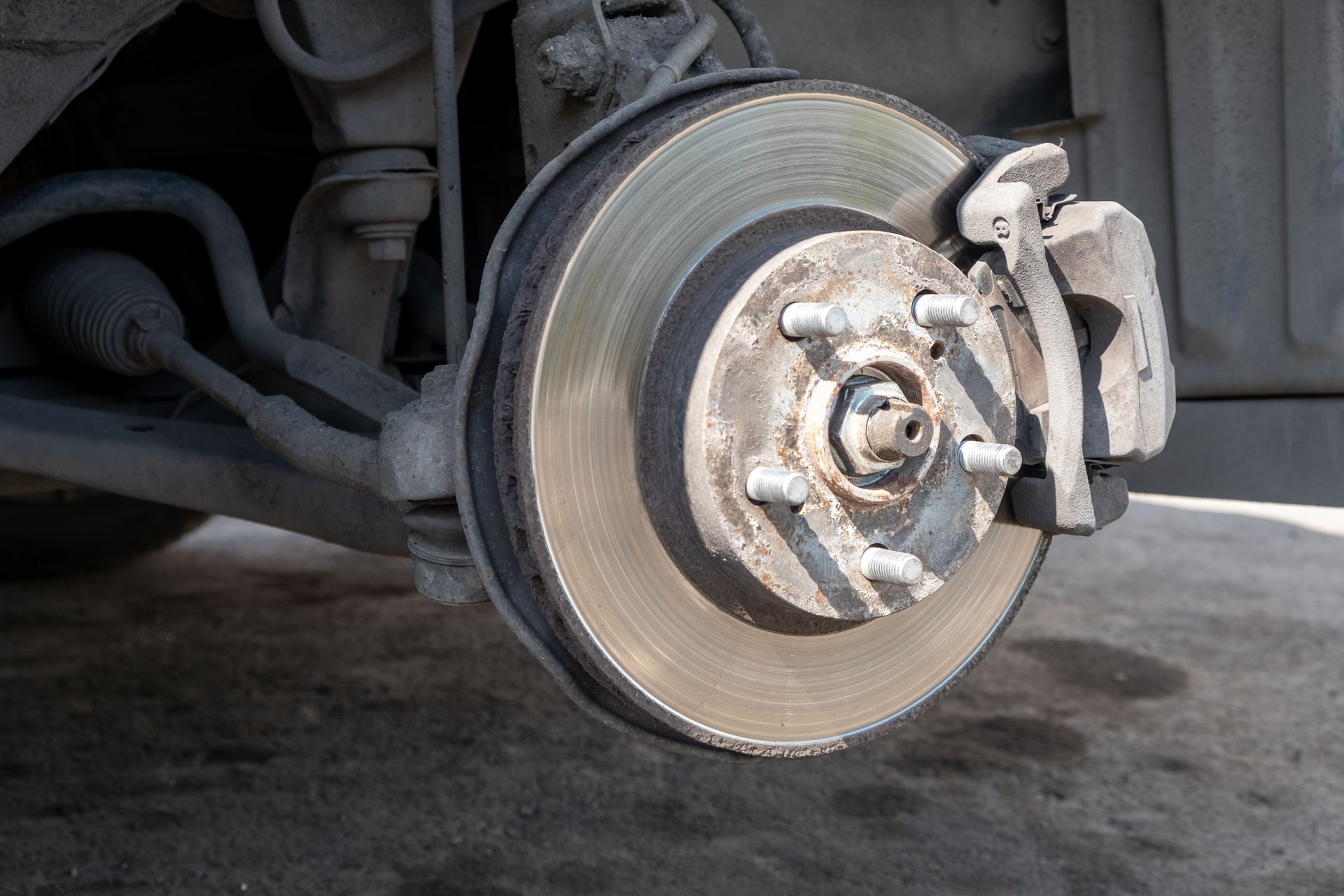 Close-Up View Of A Vehicle Brake Rotor And Caliper During Brake Inspection | Kingwood Tire & Automotive