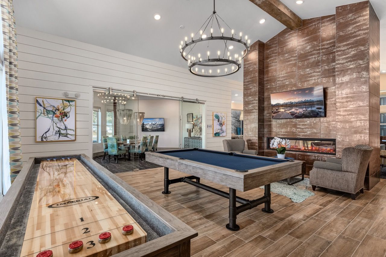 Communal game room with pool table, shuffleboard, fireplace and lounge seating.